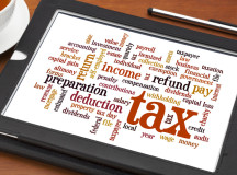 cloud  of words related to taxes, preparation, paying, income, refunds, on a digital tablet with a cup of tea